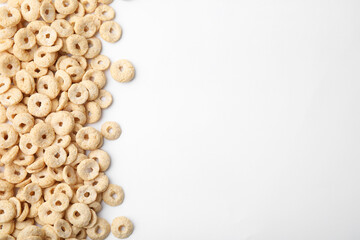 Tasty cereal rings on white background, flat lay. Space for text