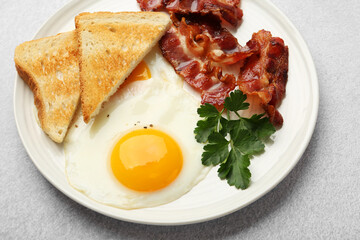 Delicious breakfast with sunny side up egg on light table, closeup