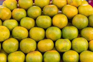 ripe tangerines with green peel as background.
