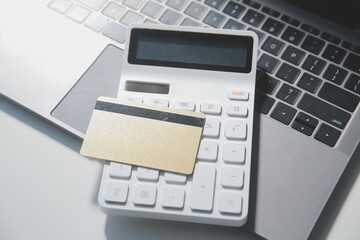 Calculator on a dark background, plastic cards and banknotes