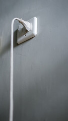 White electrical cable into the socket. Home shot.