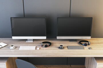Two empty gaming computer screens on desk with coffee cups and headsets. Place for your advertisement. Gaming club concept. Mock up, 3D Rendering.