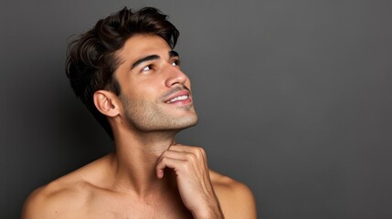 A shirtless man with his hand on his chin, deep in contemplation