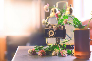 Vintage style, analogue camera on the table and summer flowers. Summer or Autumn season concept....