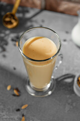 Masala tea on transparent cup. Indian tea with milk and spices on concrete background. Black tea...
