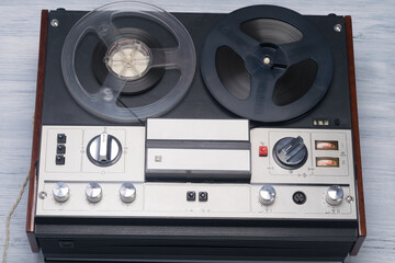 On the table lies an old magnetic tape player of retro hits, music