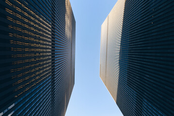 Bottom up view of modern skyscrapers with a blue sky on the background