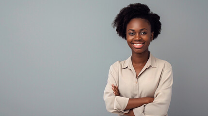 Heureuse jeune femme africaine, d'affaires professionnelle souriante et confiante portant une chemise beige, une femme cadre assez élégante regardant la caméra, debout, les bras croisés isolés sur fon