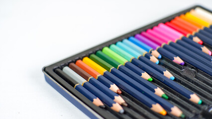 Naklejka premium Set of color pencils with different size in pencil case on a white background