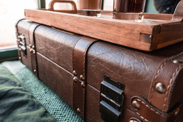 Close up Vintage leather suitcase luggage with wooden coffee tray