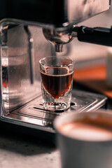 Preparing espresso coffee in automatic home small coffee machine. Close up image of coffee espresso drops
