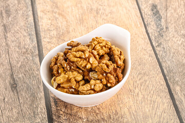 Cracked unshelled walnut in the bowl