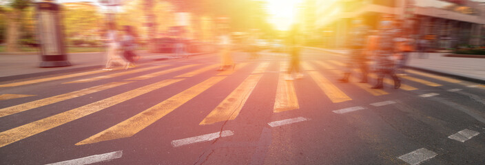 Crossing area, yellow lines, people crossing the road blurred, stock photo