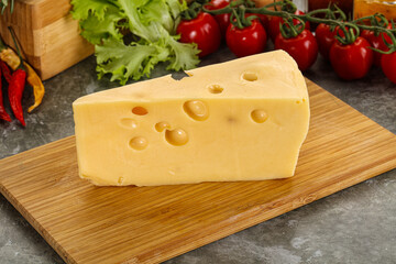 Swiss Maasdam cheese triangle over board