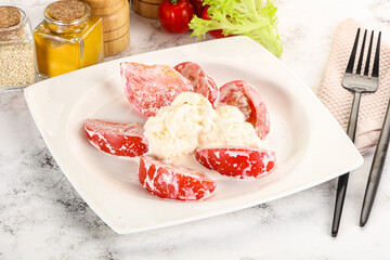Salad with sliced tomato and stracciatella
