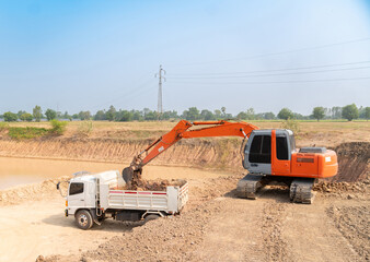 Excavator loading dumper trucks.