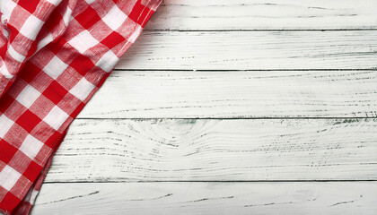 Old white vintage wooden table with red checkered tablecloth.