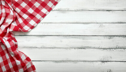 Old white vintage wooden table with red checkered tablecloth.