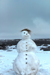 Handmade snowman melting slowly in the early spring in Iceland