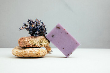 Handmade soap from natural ingredients, various herbs, lavender. Concept of sustainable use, bath product on concrete background. Front view
