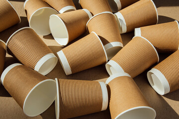 A set of paper utensils, brown cups on a brown background. Eco friendly, zero waste concept. Front...