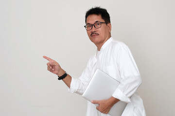Side view: A man pointed at the direction he was heading and held a laptop in his hand