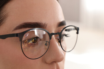 Woman wearing glasses on blurred background, closeup