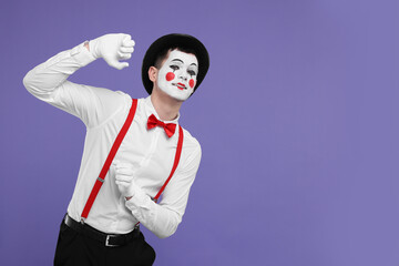Funny mime artist in hat posing on purple background. Space for text