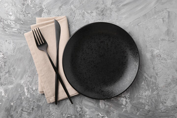 Elegant setting with stylish cutlery on grey textured table, flat lay