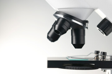 Modern microscope on light background, closeup view. Space for text