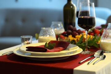 Stylish table setting with burning candles and wine, closeup. Romantic dinner