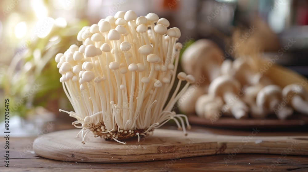 Poster Close-up view of fresh enoki mushrooms on a wooden board in a rustic kitchen setting.