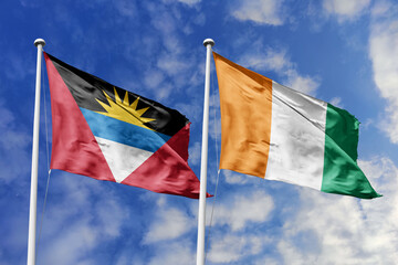  3d illustration. Antigua and Barbuda and Ivory Coast Flag waving in sky. High detailed waving flag. 3D render. Waving in sky. Flags fluttered in the cloudy sky.