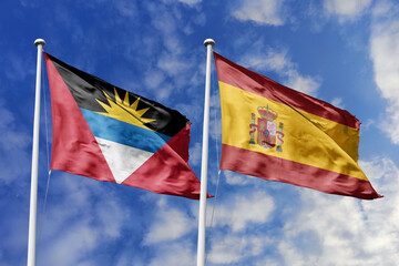 3d illustration. Antigua and Barbuda and Spain Flag waving in sky. High detailed waving flag. 3D render. Waving in sky. Flags fluttered in the cloudy sky.