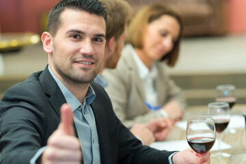businessman thumbs up with glass of red wine