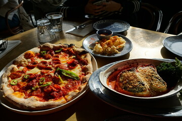 Close up Traditional Pepperoni and cheese Pizza served with cheesy eggplant and bread toast