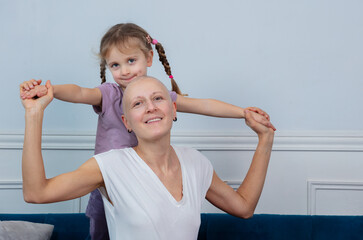 Happy child and adult woman ill of cancer sharing fun together