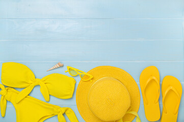 Flat lay with yellow summer outfit on wooden background. Vacation concept