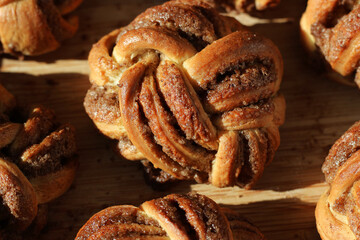 Delicious Buttery Cinnamon Buns Closeup on Wooden Board. Bakery Pastry.