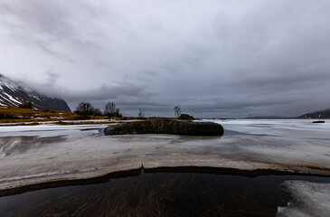Rocks in front of a frozen lake in the Lofoten Islands