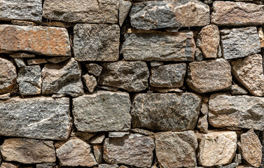 Stone wall made up of different sizes, shapes and colors of field rocks
