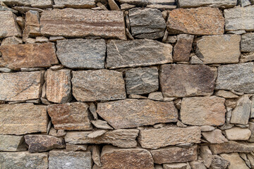 Stone wall made up of different sizes, shapes and colors of field rocks