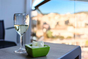 Glass of white wine cafe and fruit light snack on table in sunlight. Atmosphere of delightful event and romantic summer