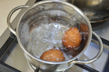 the eggs are boiled in water in a saucepan. food for breakfast. background for the design.