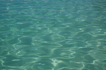 Blue water with ripples on the surface. Defocus blurred transparent blue clear calm water surface...