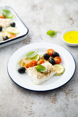 Roasted cod with olives, tomato and zucchini