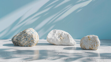 This abstract background is ideal for product presentation, featuring a soothing blue and white color palette. Three rough rocks rest on the floor, casting soft shadows that add depth and dimension 