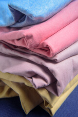 Dobleces en lateral de pila de camisetas de algodon de colores 