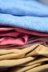 Dobleces en lateral de pila de camisetas de algodon de colores 