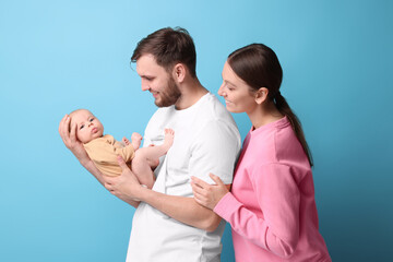 Happy family. Parents with their cute baby on light blue background
